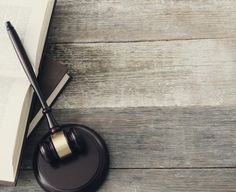 a judge's gavel and book on a wooden table