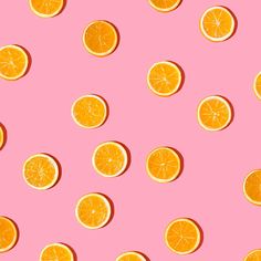 orange slices are arranged on a pink background