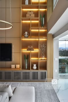 a living room filled with furniture and a flat screen tv sitting on top of a wooden shelf