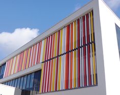 a building with multicolored lines painted on it's side and windows in the front