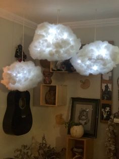 some clouds are hanging from the ceiling in a room with pictures and other decorations on the wall