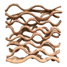 a sculpture made out of driftwood with wavy lines on the top and bottom, against a white background