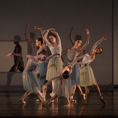 a group of people that are standing in the middle of a dance pose on a stage