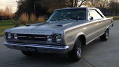 an old car is parked in the driveway