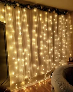 a bedroom with lights on the wall and curtains