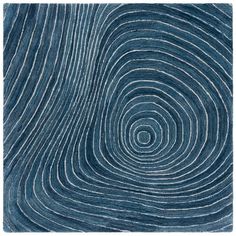 a blue rug with wavy lines in the middle and an oval design on top of it