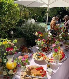 a table topped with lots of food and flowers