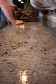 a close up of a counter top with a person working on the table in the background