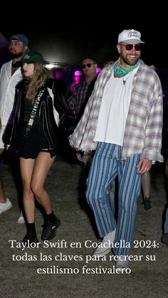 a man and woman are walking together in the grass with other people behind them at night