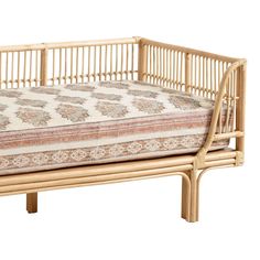 a bed made out of bamboo with a cushion on it's side and back