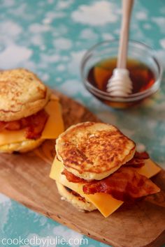 two pancakes with bacon and cheese on a cutting board