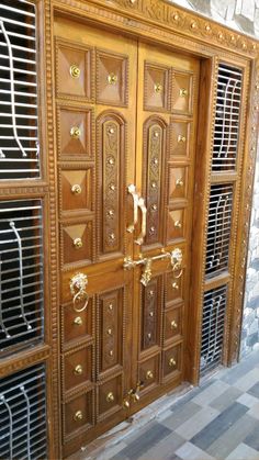 an ornate wooden door with metal grills on it