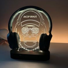 an illuminated headphone stand with a headset on it's face and the name jacop braus