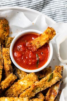 some fried food on a white plate with sauce in the bowl and dipping sauce for dipping