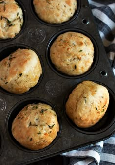 four muffins in a black tray on a table