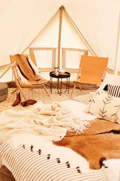 the interior of a teepee with chairs and rugs on the floor in front of it