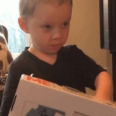 a young boy holding a box with an electronic device in it