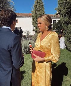 a woman in a yellow dress standing next to a man