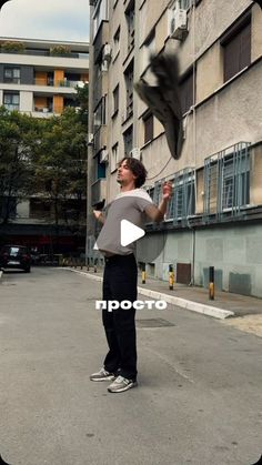 a man standing in the middle of an empty parking lot with a bird flying over him