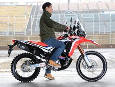 a man riding on the back of a dirt bike in front of an empty stadium