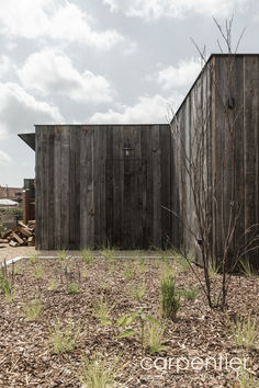 an old wooden building sitting on top of a dry grass field