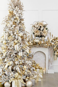 a decorated christmas tree in front of a fireplace with gold and silver decorations on it