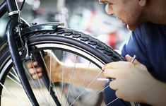 a man is working on a bicycle tire