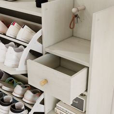 shoes are stored on shelves in a shoe storage area, with one drawer open and the other closed