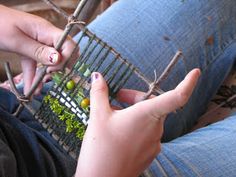 a person is sitting on the ground and holding something in their hand