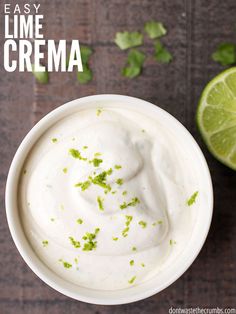 a white bowl filled with lime cream and garnished with cilantro