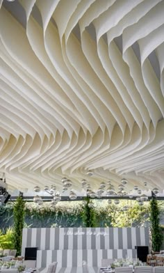 an artisticly designed restaurant with white tables and chairs