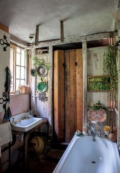 an old fashioned bathroom with sink, mirror and hanging potted plant on the wall