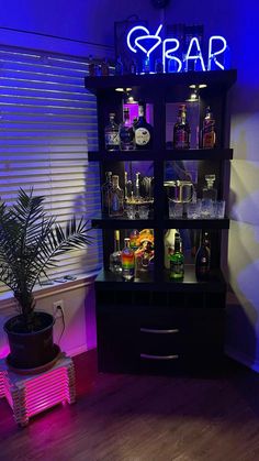 an illuminated bar shelf with liquor bottles and glasses on it in front of a window