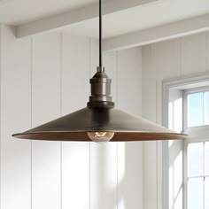 a kitchen light hanging from the ceiling in front of a window with white paneling