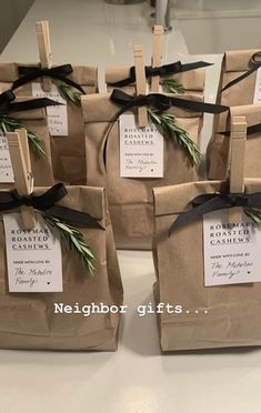 four brown bags with black ribbons and tags on them are sitting on a counter top