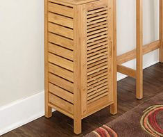 a wooden cabinet sitting on top of a hard wood floor next to a rug and wall