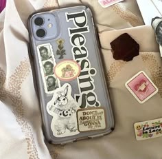 there is a cell phone case with stickers on it and other things around it