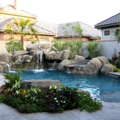 a backyard with a pool and waterfall