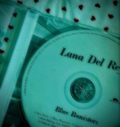 a cd that is sitting on top of a bed with the words lana del re