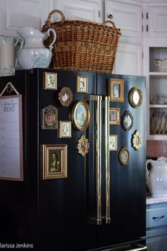 a black refrigerator with gold trim and pictures on the door, next to a wicker basket