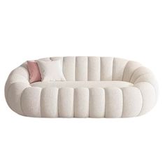 a white couch with pillows on it and a pink pillow in the middle of it