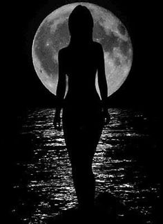 the silhouette of a woman standing in front of a full moon with water below her