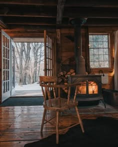 a chair sitting in front of a fire place inside of a wooden cabin next to a window