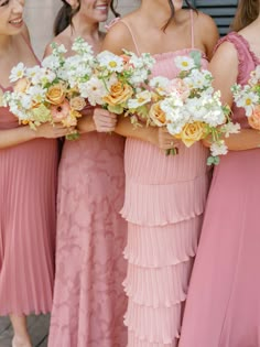 the bridesmaids are all wearing pink dresses and holding bouquets in their hands