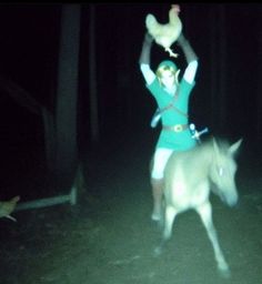 a woman is riding on the back of a horse at night with a chicken in her hand