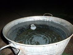 an old metal bucket filled with water and a white object in the middle of it