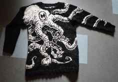 an octopus sweater is laying on the floor