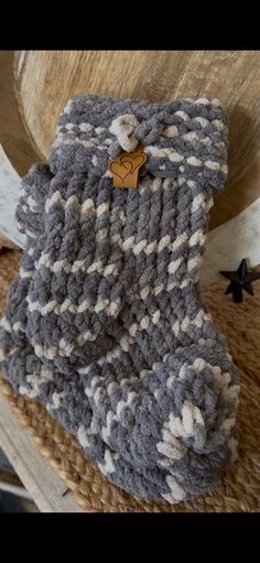 a gray and white knitted blanket sitting on top of a wooden chair next to a star