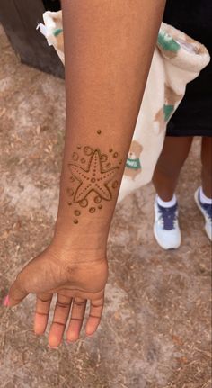 a woman's arm with a tattoo on it and her hand in the air