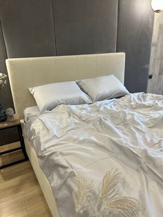 a bed with white sheets and pillows in a room